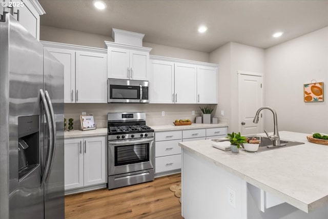 31363 NW N Ave, North Plains, OR 97133 - kitchen featuring appliances with stainless steel finishes, white cabinetry, light countertops, recessed lighting, and light wood-style floors