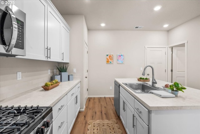 31363 NW N Ave, North Plains, OR 97133 - kitchen featuring stainless steel appliances, a sink, a kitchen island with sink, light countertops, and light wood-style flooring