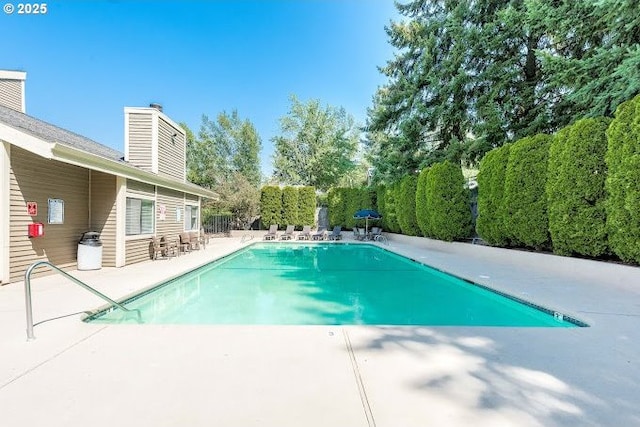 community pool featuring a patio and fence