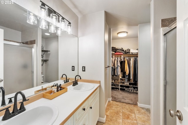 bathroom with a stall shower, a spacious closet, double vanity, tile patterned flooring, and toilet