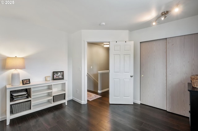 bedroom featuring dark wood finished floors, a closet, and baseboards