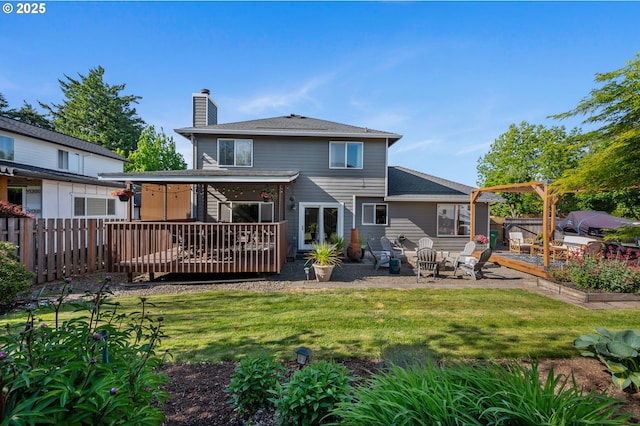 rear view of house with a chimney, a deck, and a patio