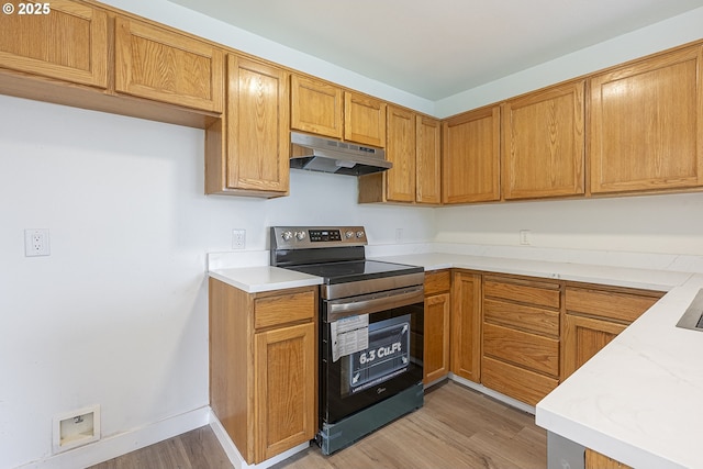 kitchen with electric stove, brown cabinets, light countertops, light wood-type flooring, and under cabinet range hood