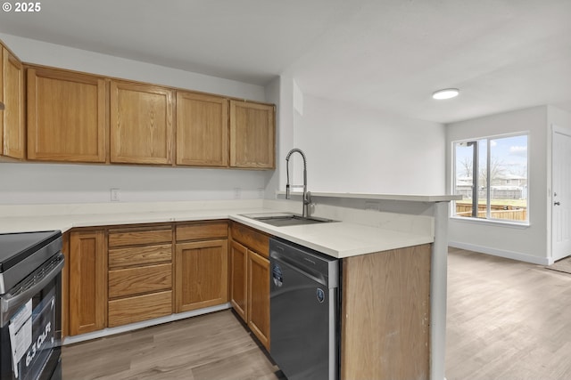 kitchen featuring stainless steel dishwasher, a sink, light wood-type flooring, black range with electric cooktop, and a peninsula