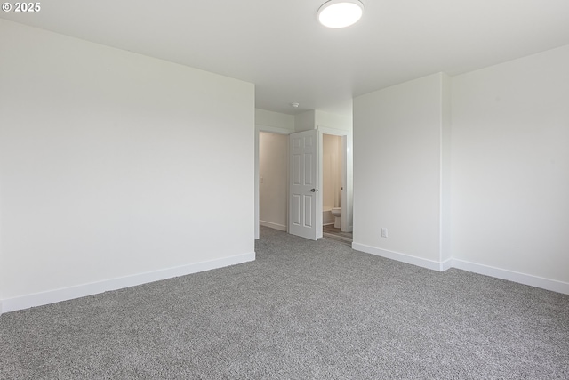 carpeted empty room featuring baseboards