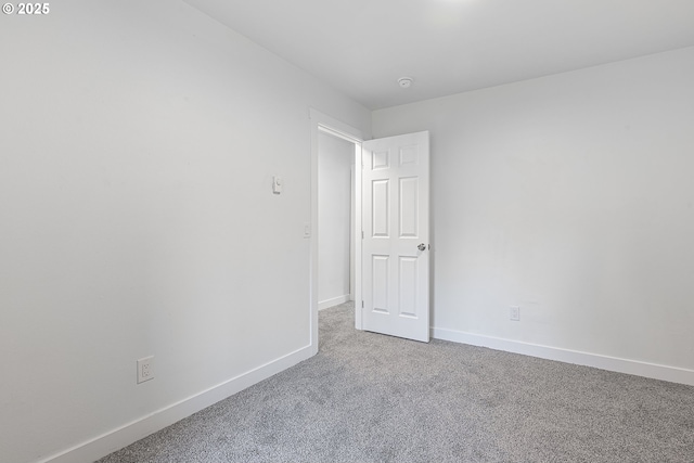 carpeted empty room with baseboards