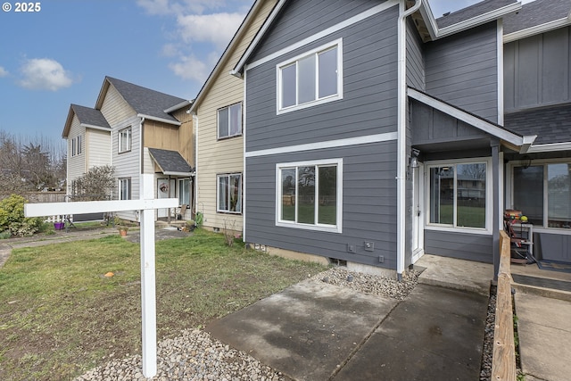 view of side of property featuring a lawn and a patio area