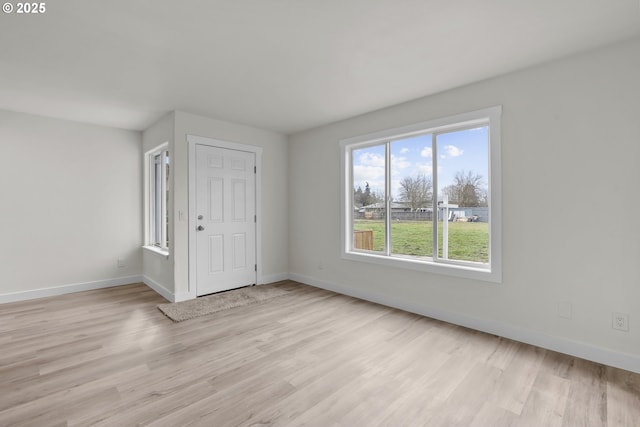 foyer featuring light wood finished floors and baseboards