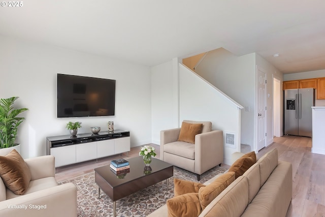 living area with light wood-type flooring and visible vents