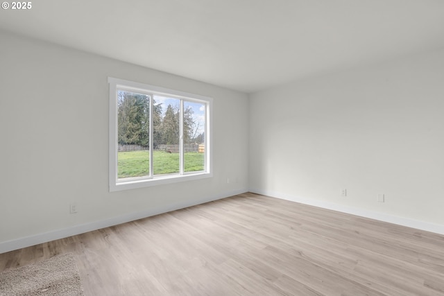 unfurnished room featuring baseboards and light wood finished floors