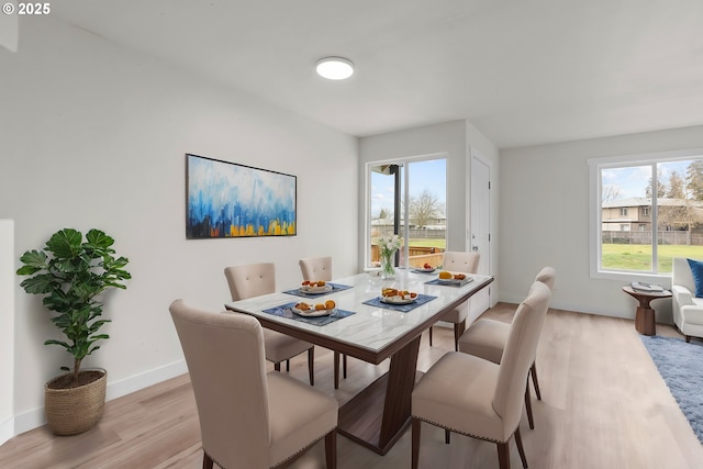 dining room with plenty of natural light, light wood-style flooring, and baseboards