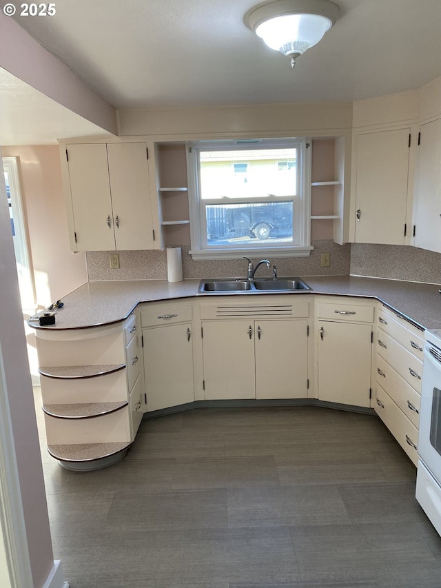 kitchen with white range with electric stovetop, a sink, and open shelves