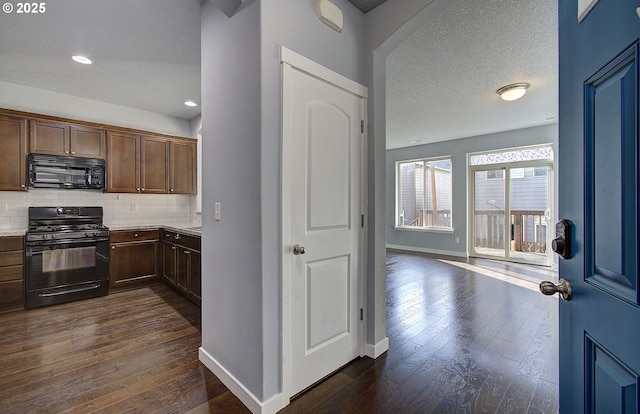 kitchen featuring decorative backsplash, black appliances, dark wood-type flooring, and light countertops