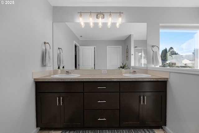 bathroom with a shower with shower door and vanity