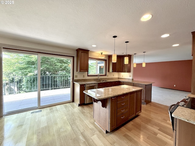 5235 SE 32nd Ave, Portland, OR 97202 - kitchen featuring dishwasher, gas range, a peninsula, light wood-type flooring, and a kitchen island