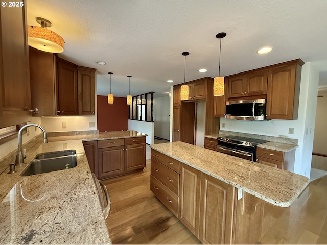 5235 SE 32nd Ave, Portland, OR 97202 - kitchen featuring stainless steel microwave, black / electric stove, light wood-style floors, recessed lighting, and light stone counters