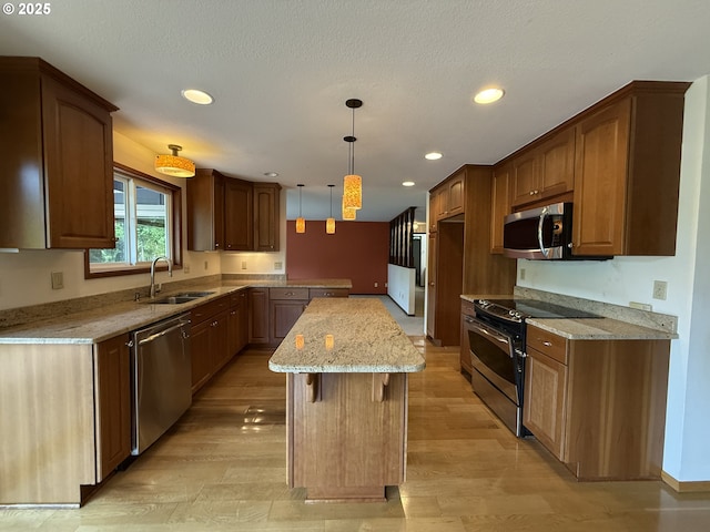 5235 SE 32nd Ave, Portland, OR 97202 - kitchen with appliances with stainless steel finishes, light stone countertops, recessed lighting, a kitchen island, and light wood finished floors