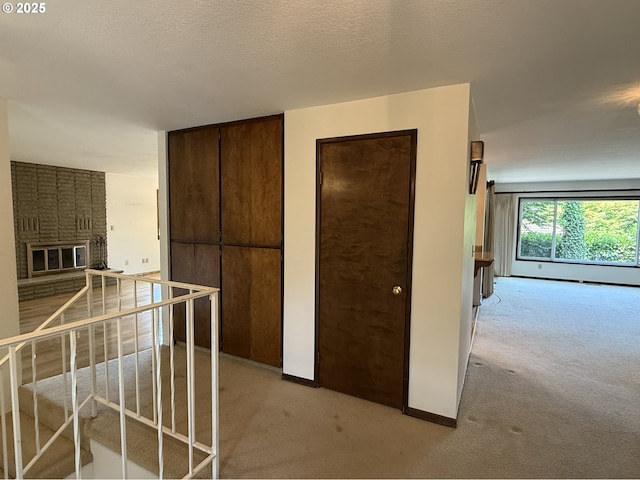 5235 SE 32nd Ave, Portland, OR 97202 - kitchen featuring light carpet, a brick fireplace, open floor plan, and dark brown cabinetry