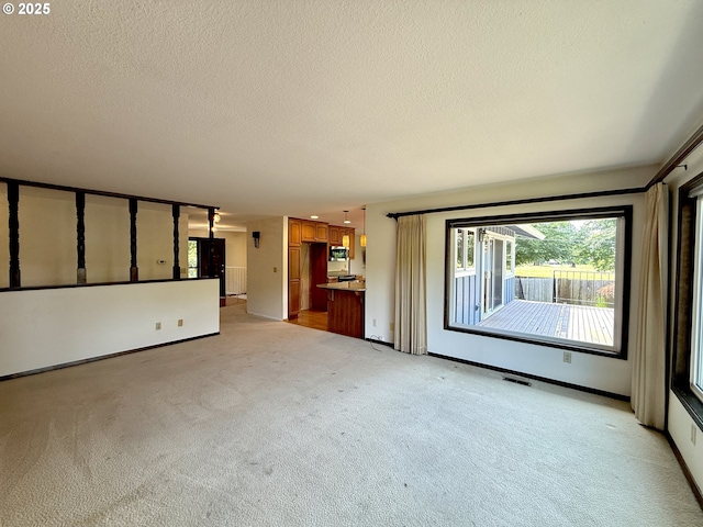 5235 SE 32nd Ave, Portland, OR 97202 - unfurnished living room with light colored carpet and a textured ceiling