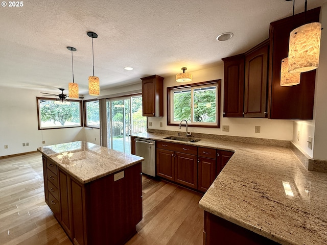 5235 SE 32nd Ave, Portland, OR 97202 - kitchen featuring stainless steel dishwasher, a kitchen island, a ceiling fan, light wood finished floors, and a textured ceiling