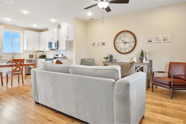 living room featuring visible vents, recessed lighting, a ceiling fan, and light wood-style floors