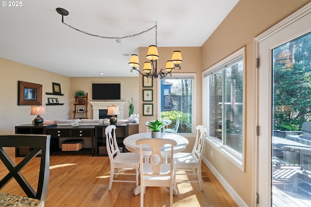 dining room featuring a notable chandelier, light wood-type flooring, and baseboards