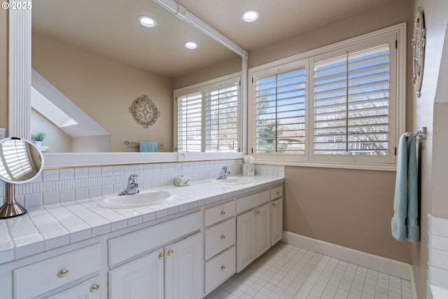 5666 Grand Oaks Dr, Lake Oswego, OR 97035 - full bath with a skylight, double vanity, baseboards, recessed lighting, and decorative backsplash