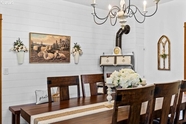 dining room featuring a chandelier and wood walls