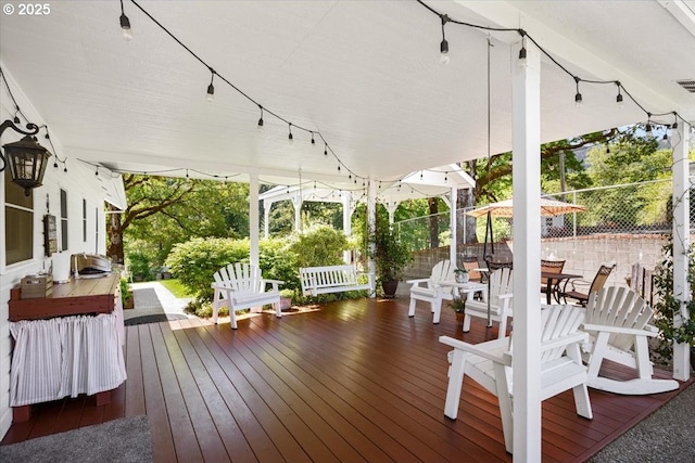 wooden deck with outdoor dining space and fence