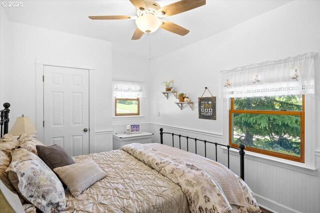bedroom with wainscoting and ceiling fan