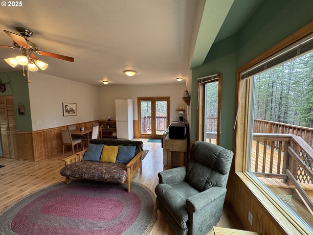 118 Noble Fir, Goldendale, WA 98620 - living room featuring wood finished floors, lofted ceiling, wooden walls, a wainscoted wall, and a ceiling fan