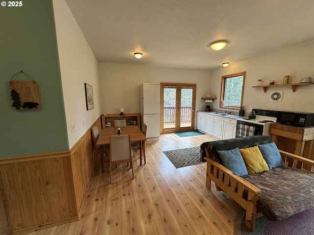 118 Noble Fir, Goldendale, WA 98620 - living room with french doors, light wood-style flooring, wainscoting, and wood walls