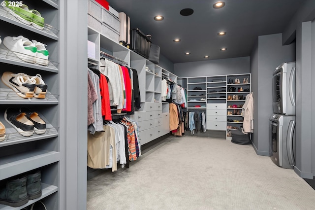 spacious closet with light carpet and stacked washing maching and dryer