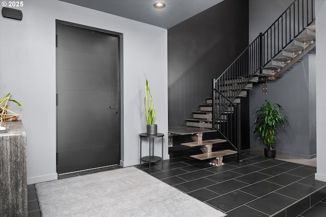 entrance foyer featuring dark tile patterned floors