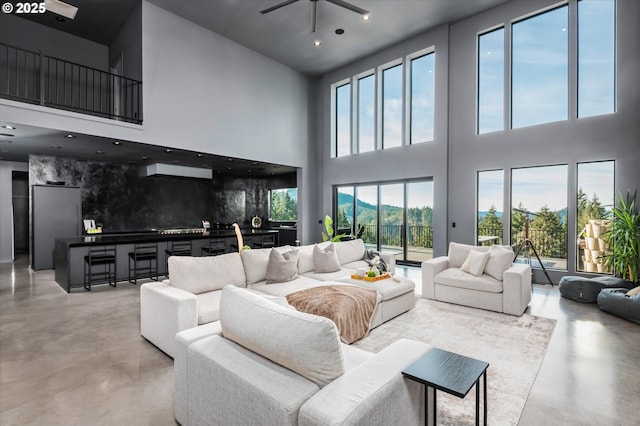 living room featuring ceiling fan and a high ceiling