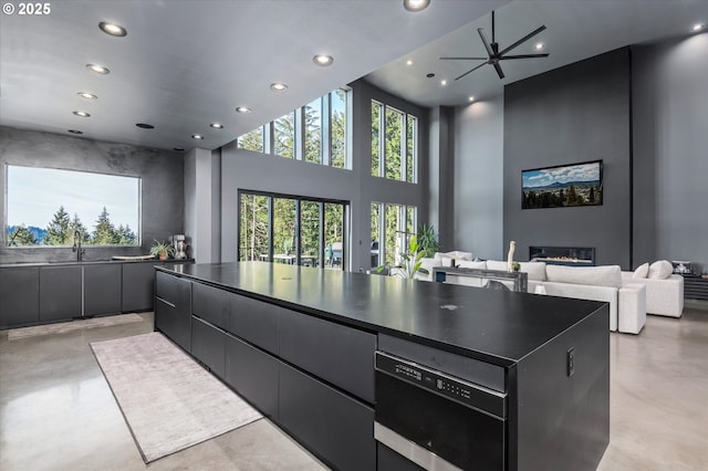 kitchen with a towering ceiling, a large island, and sink