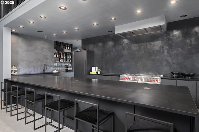 kitchen with tasteful backsplash, sink, premium appliances, a kitchen breakfast bar, and custom range hood