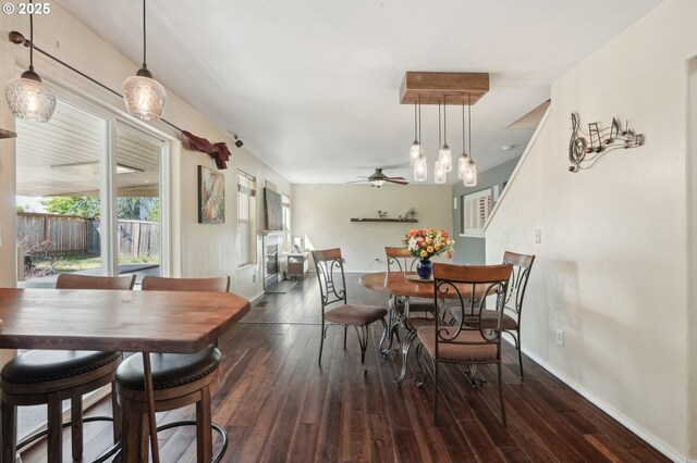 dining room featuring wood-type flooring, a ceiling fan, baseboards, and stairs