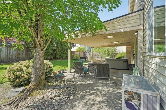view of patio with a fenced backyard and a hot tub