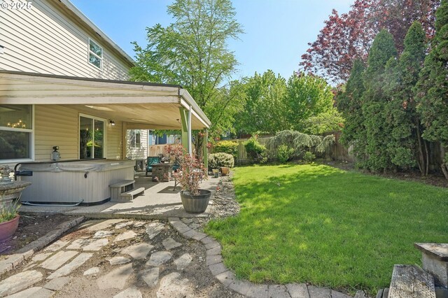 view of yard featuring a fenced backyard, a hot tub, and a patio area