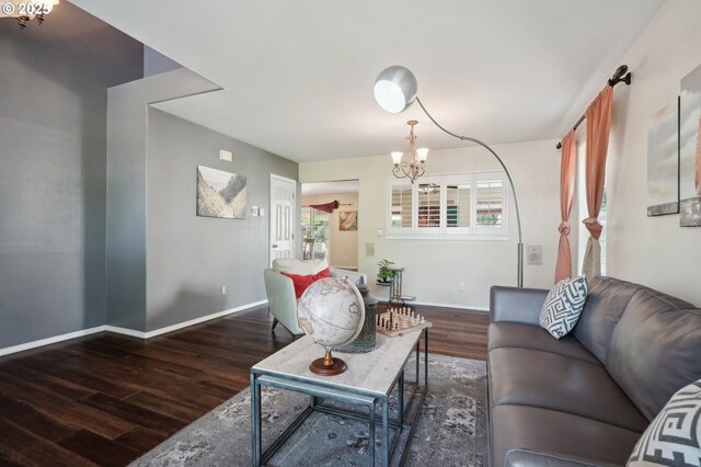 living room featuring baseboards, wood finished floors, and a chandelier