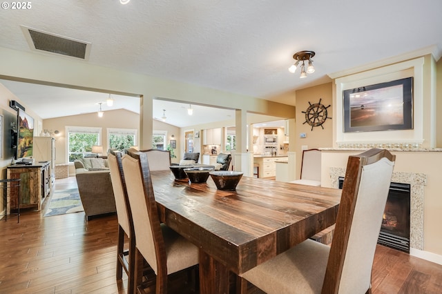 3664 W Chinook Ave, Cannon Beach, OR 97110 - dining space with lofted ceiling, hardwood / wood-style floors, and a warm lit fireplace