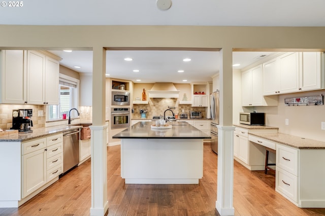 3664 W Chinook Ave, Cannon Beach, OR 97110 - kitchen with appliances with stainless steel finishes, premium range hood, light wood finished floors, decorative backsplash, and recessed lighting