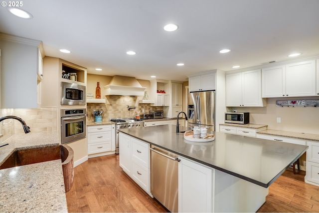 3664 W Chinook Ave, Cannon Beach, OR 97110 - kitchen featuring stainless steel appliances, premium range hood, light wood-style flooring, white cabinetry, and recessed lighting