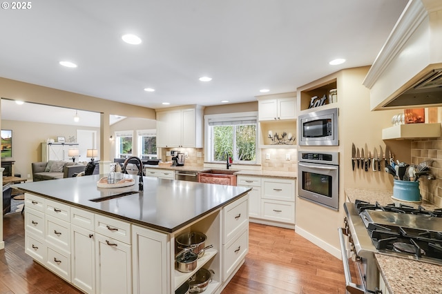 3664 W Chinook Ave, Cannon Beach, OR 97110 - kitchen with open shelves, appliances with stainless steel finishes, custom exhaust hood, light wood-style flooring, and recessed lighting