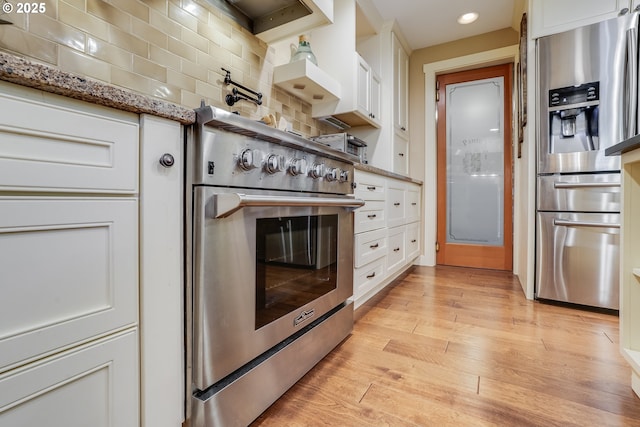 3664 W Chinook Ave, Cannon Beach, OR 97110 - kitchen featuring appliances with stainless steel finishes, decorative backsplash, white cabinets, light wood finished floors, and recessed lighting
