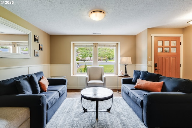 3664 W Chinook Ave, Cannon Beach, OR 97110 - living area with wood finished floors, wainscoting, and a textured ceiling