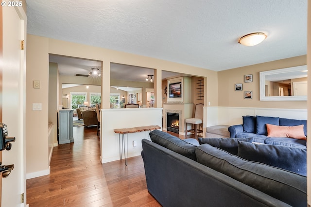 3664 W Chinook Ave, Cannon Beach, OR 97110 - living area with light wood-type flooring, a textured ceiling, and a lit fireplace