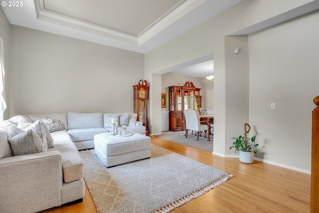 23836 SW Warbler Pl, Sherwood, OR 97140 - living room featuring wood finished floors, a raised ceiling, a chandelier, baseboards, and ornamental molding