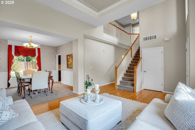 23836 SW Warbler Pl, Sherwood, OR 97140 - living room with a chandelier, stairway, wood finished floors, and a towering ceiling